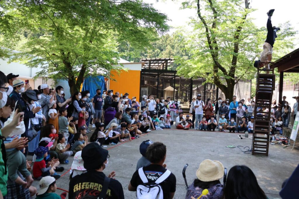 大道芸人GEN（ジェン）が宇都宮動物園 大道芸イベントで椅子を使ったサーカスショーを行って大勢の観客を集めている