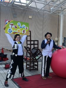 アルジェントさーかすの看板を持つ大道芸人