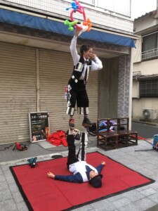 写真提供 Ma~ko~ かめいど勝運大道芸でのアクロバット!人の足の上に立って風船を作る芸